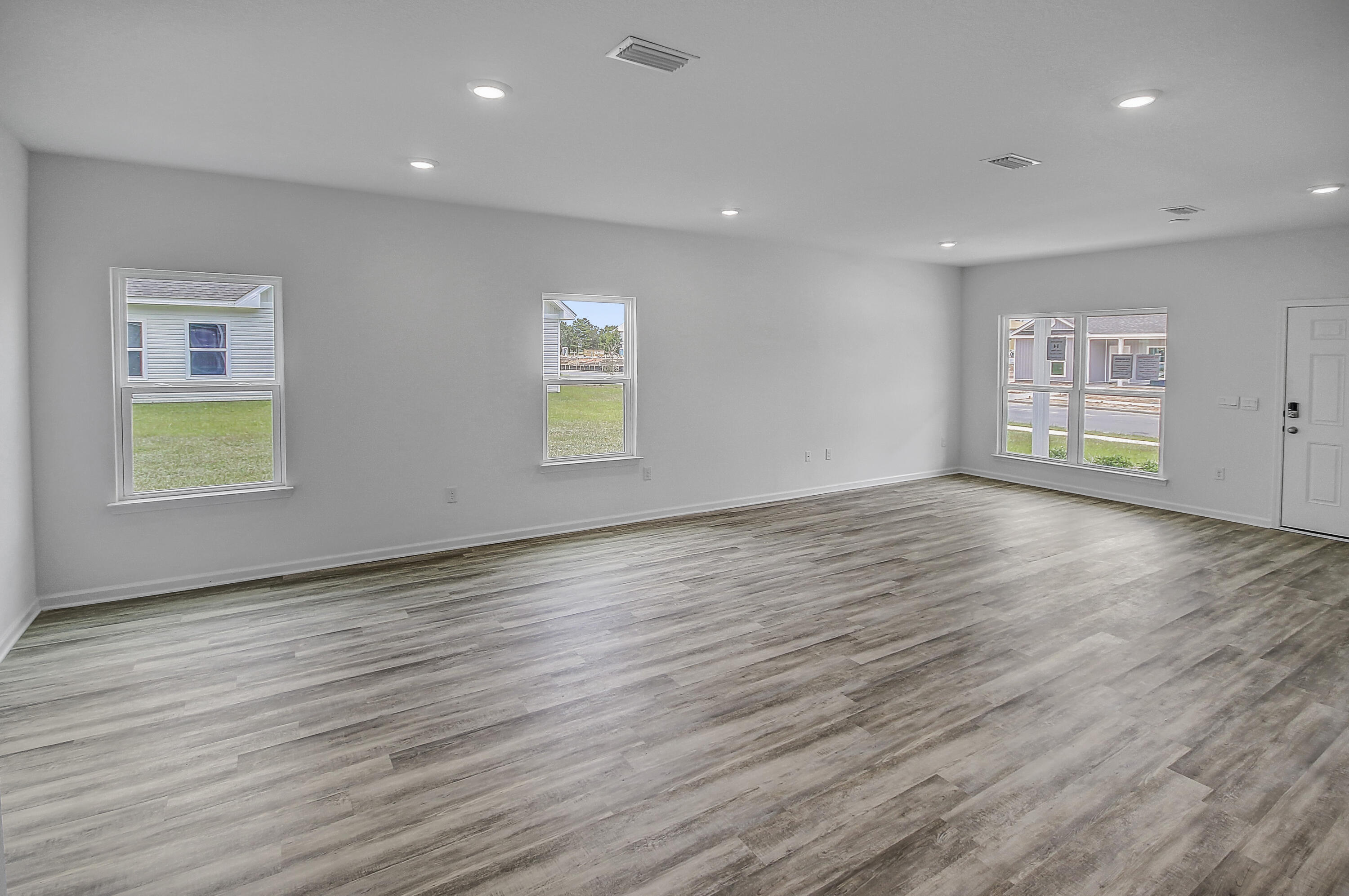247 Staggerbush Street Freeport, FL 32439 - Photo 14 of 36 an empty room with wooden floor and windows