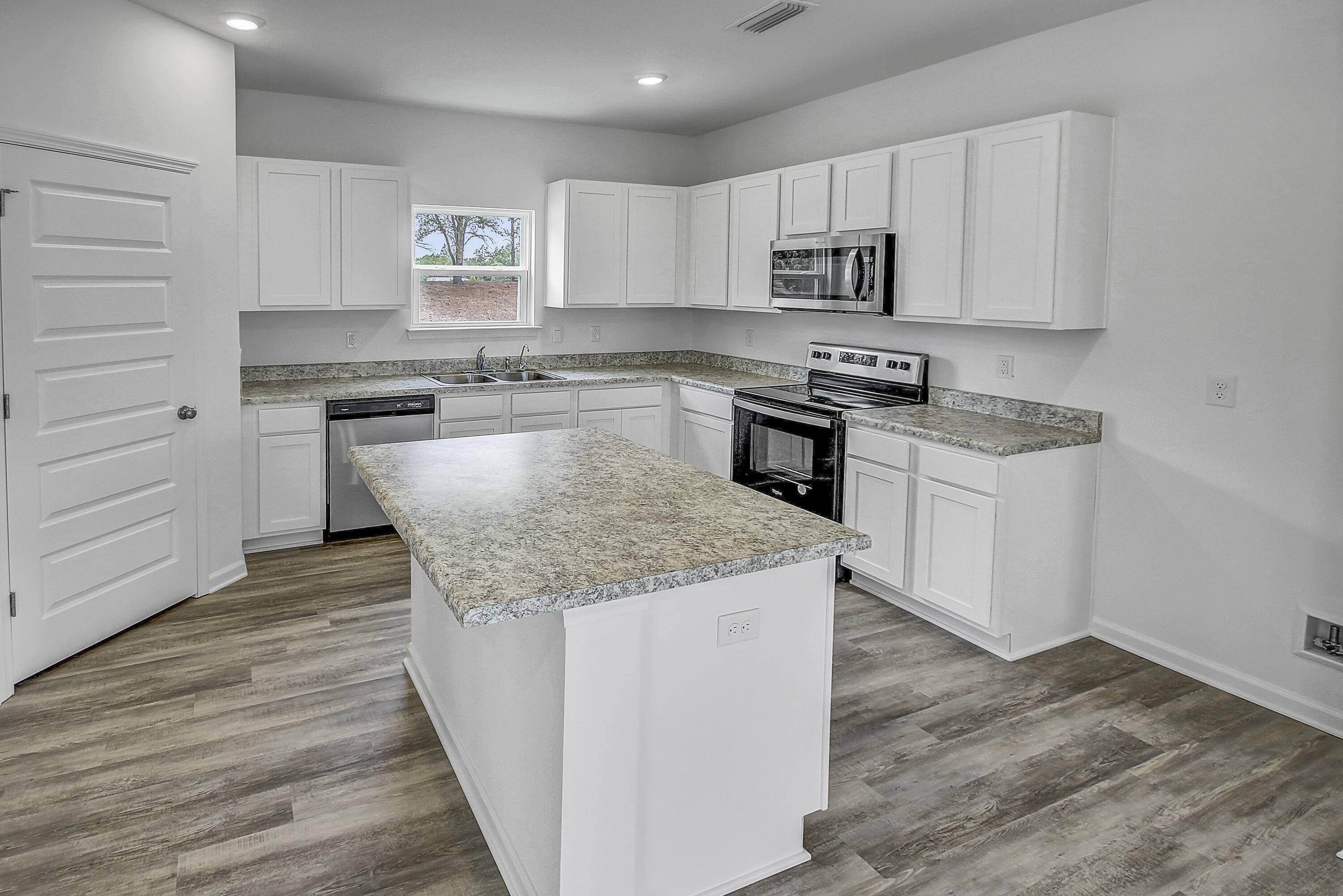 247 Staggerbush Street Freeport, FL 32439 - Photo 6 of 36 a kitchen with a stove and a microwave