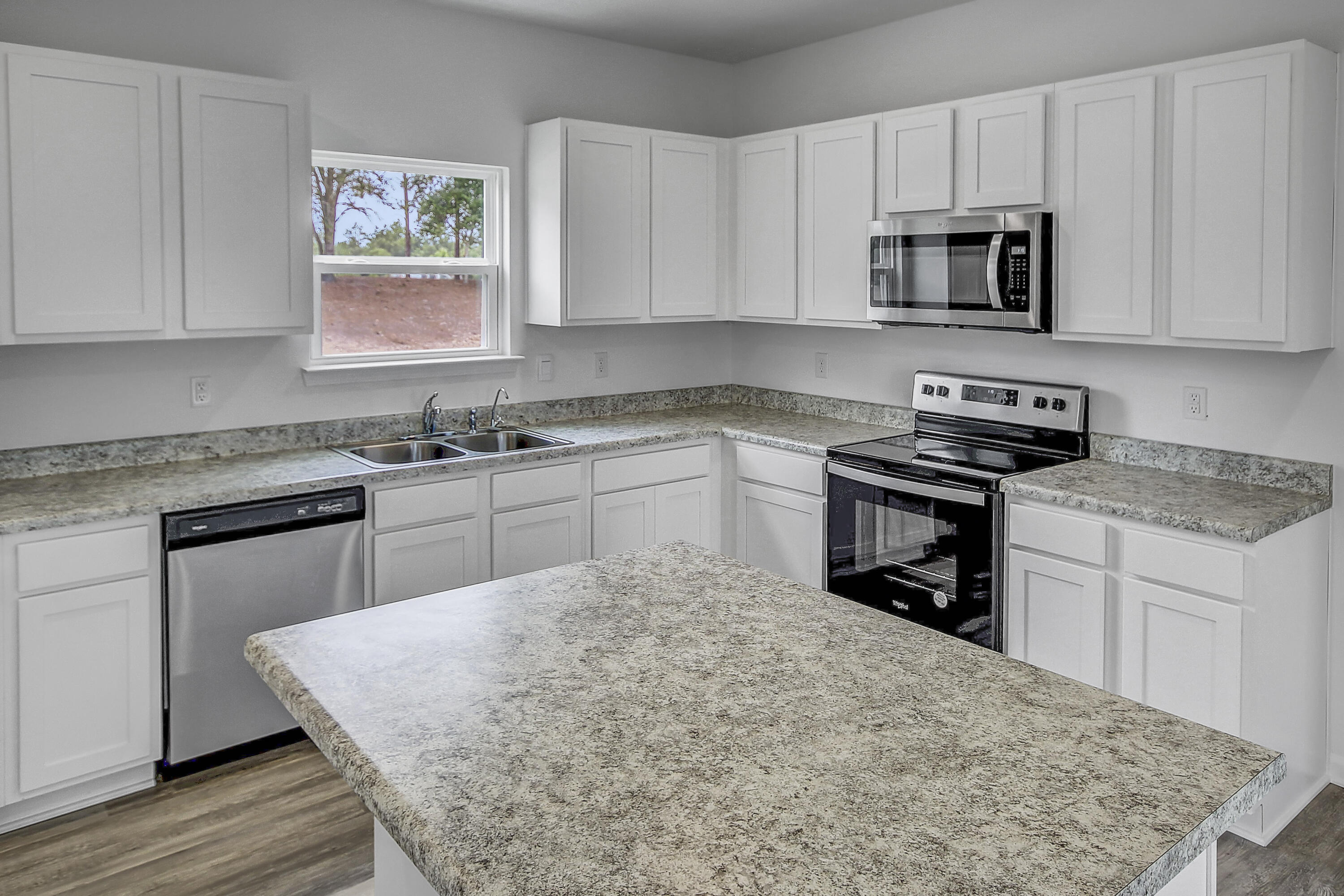 247 Staggerbush Street Freeport, FL 32439 - Photo 7 of 36 a kitchen with stainless steel appliances granite countertop a sink stove and microwave
