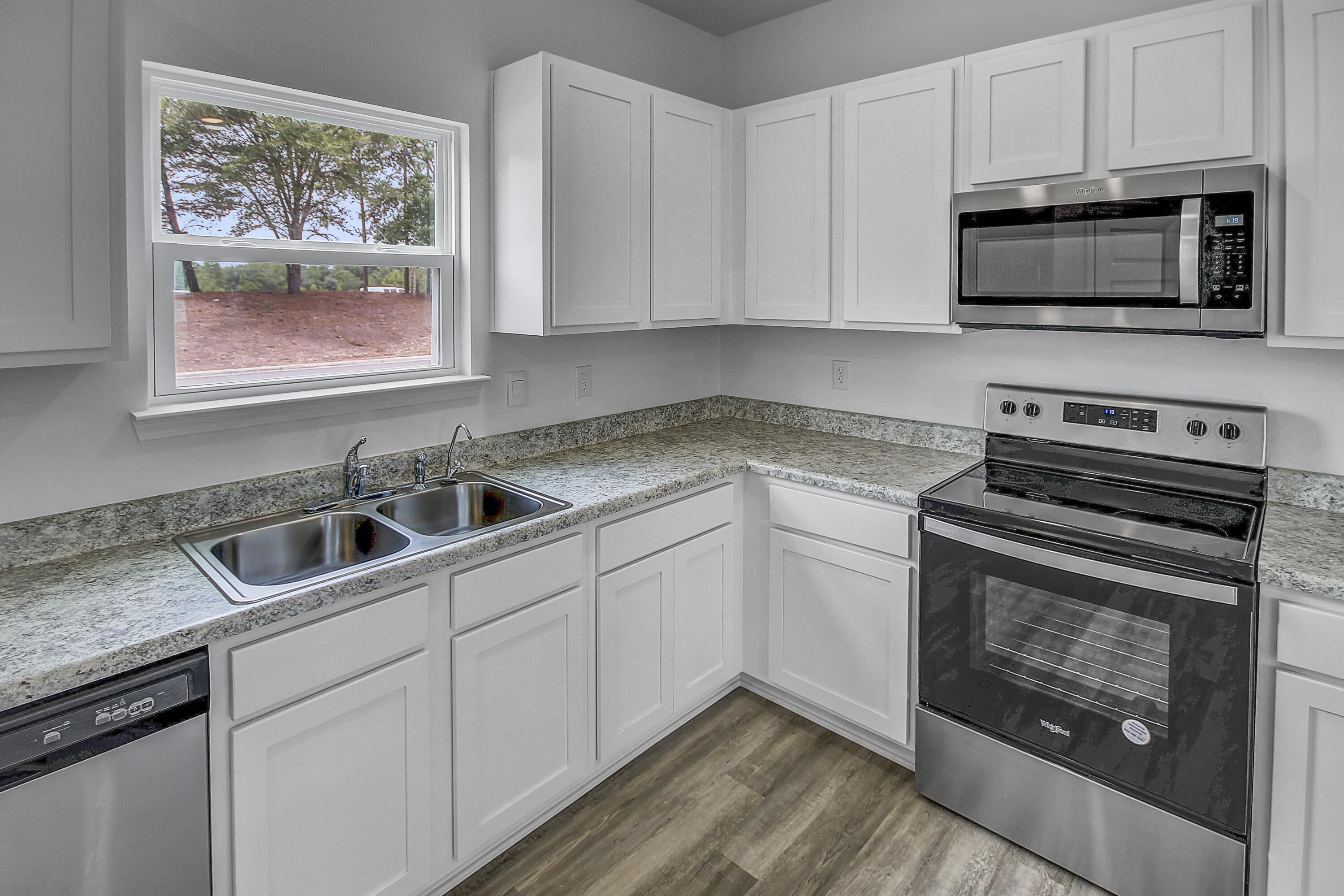 247 Staggerbush Street Freeport, FL 32439 - Photo 8 of 36 a kitchen with stainless steel appliances granite countertop a stove microwave and sink