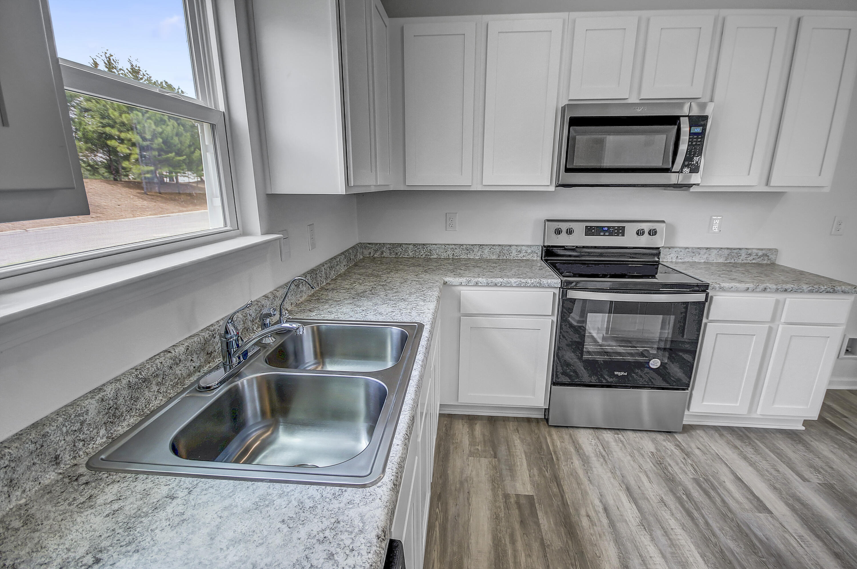 247 Staggerbush Street Freeport, FL 32439 - Photo 9 of 36 a kitchen with granite countertop a stove and a sink