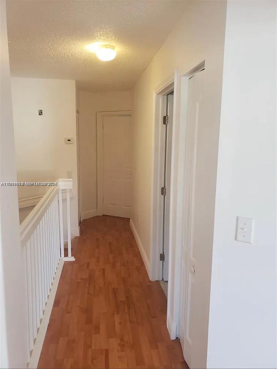14212 Southwest 121st Place, Unit 6 Miami, FL 33186 - Photo 14 of 19 a view of a hallway with wooden floor