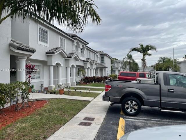 14212 Southwest 121st Place, Unit 6 Miami, FL 33186 - Photo 4 of 19 a view of a car park in front of a house