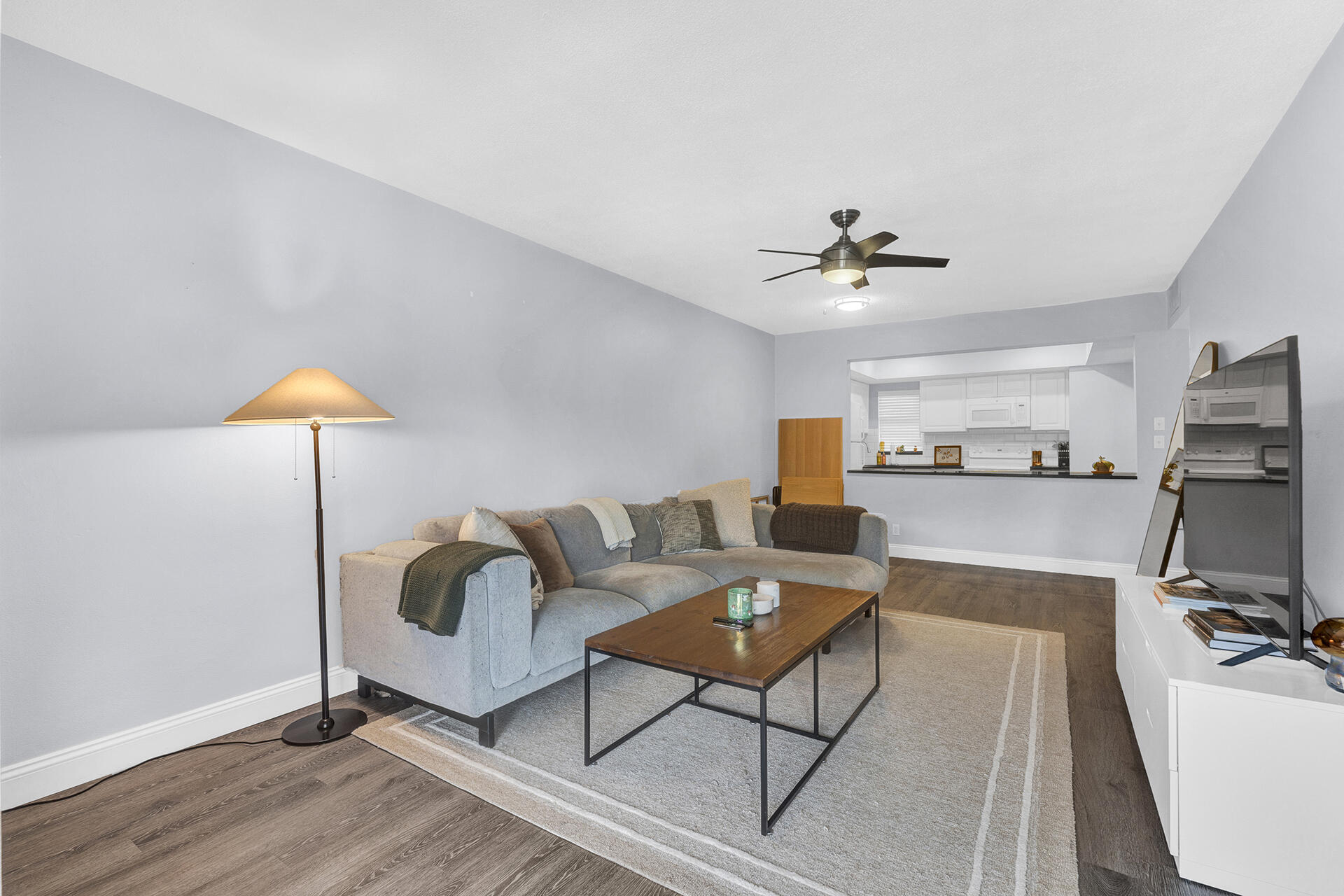 6100 Northeast 7th Avenue, Unit 20 Boca Raton, FL 33487 - Photo 17 of 42 a living room with furniture and a flat screen tv with wooden floor