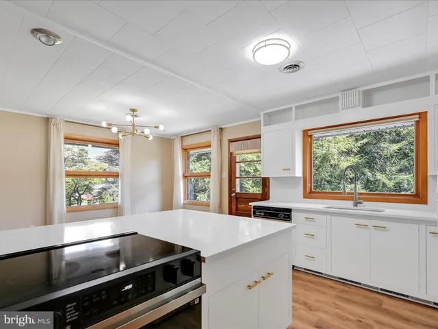 a kitchen with a large window and cabinets