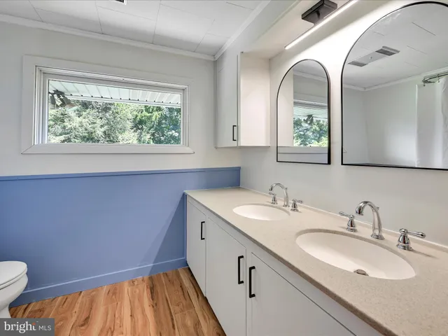 a en suite bathroom with a granite countertop sink and a window