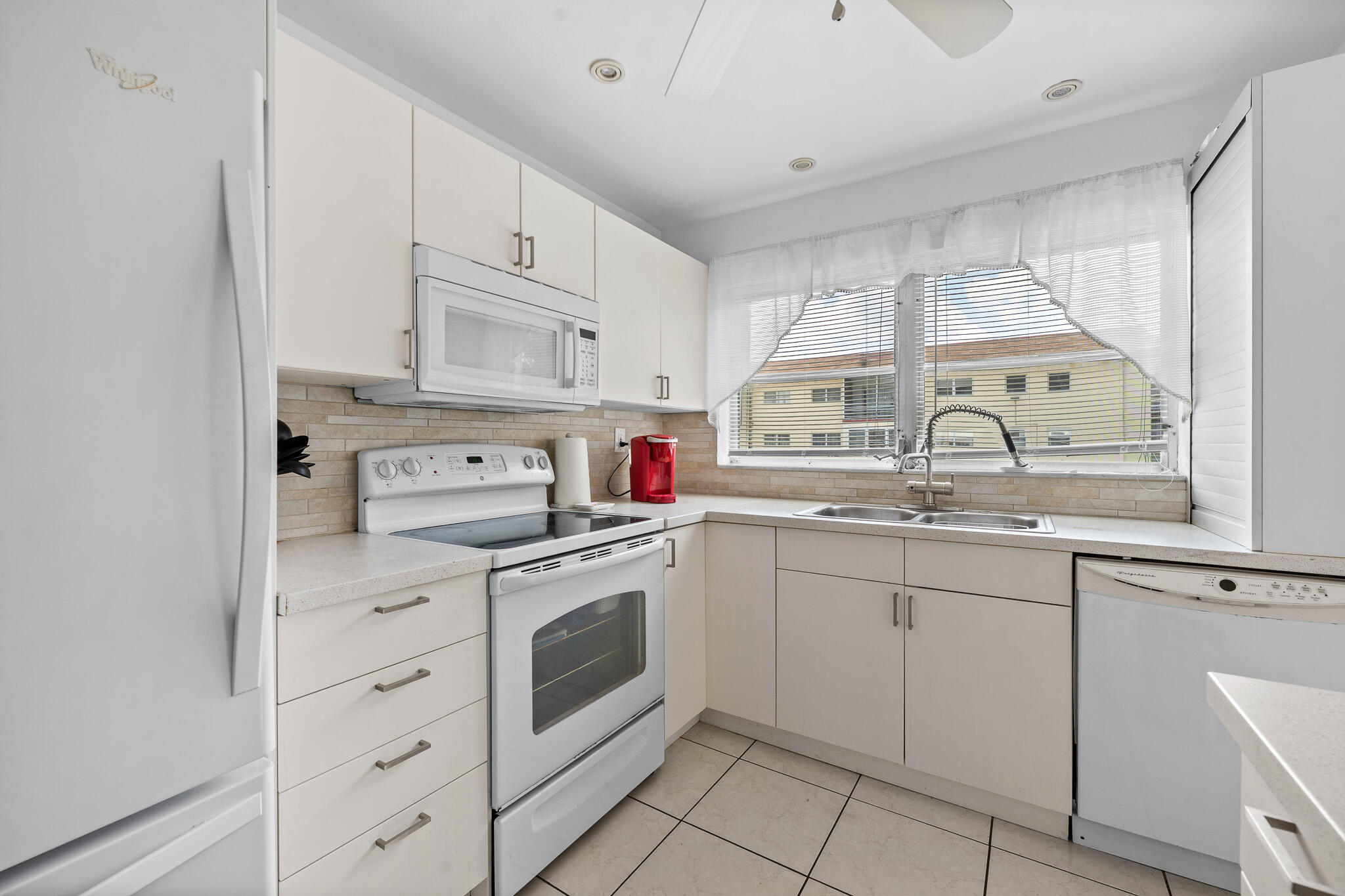 4047 Northwest 16th Street, Unit 206 Lauderhill, FL 33313 - Photo 11 of 26 a kitchen with cabinets appliances and a window
