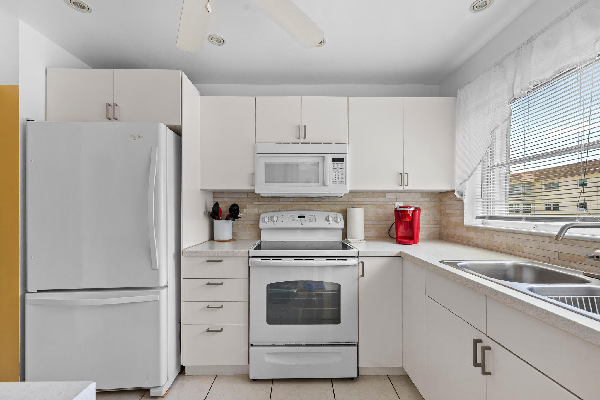 4047 Northwest 16th Street, Unit 206 Lauderhill, FL 33313 - Photo 12 of 26 a kitchen with cabinets a refrigerator and a sink