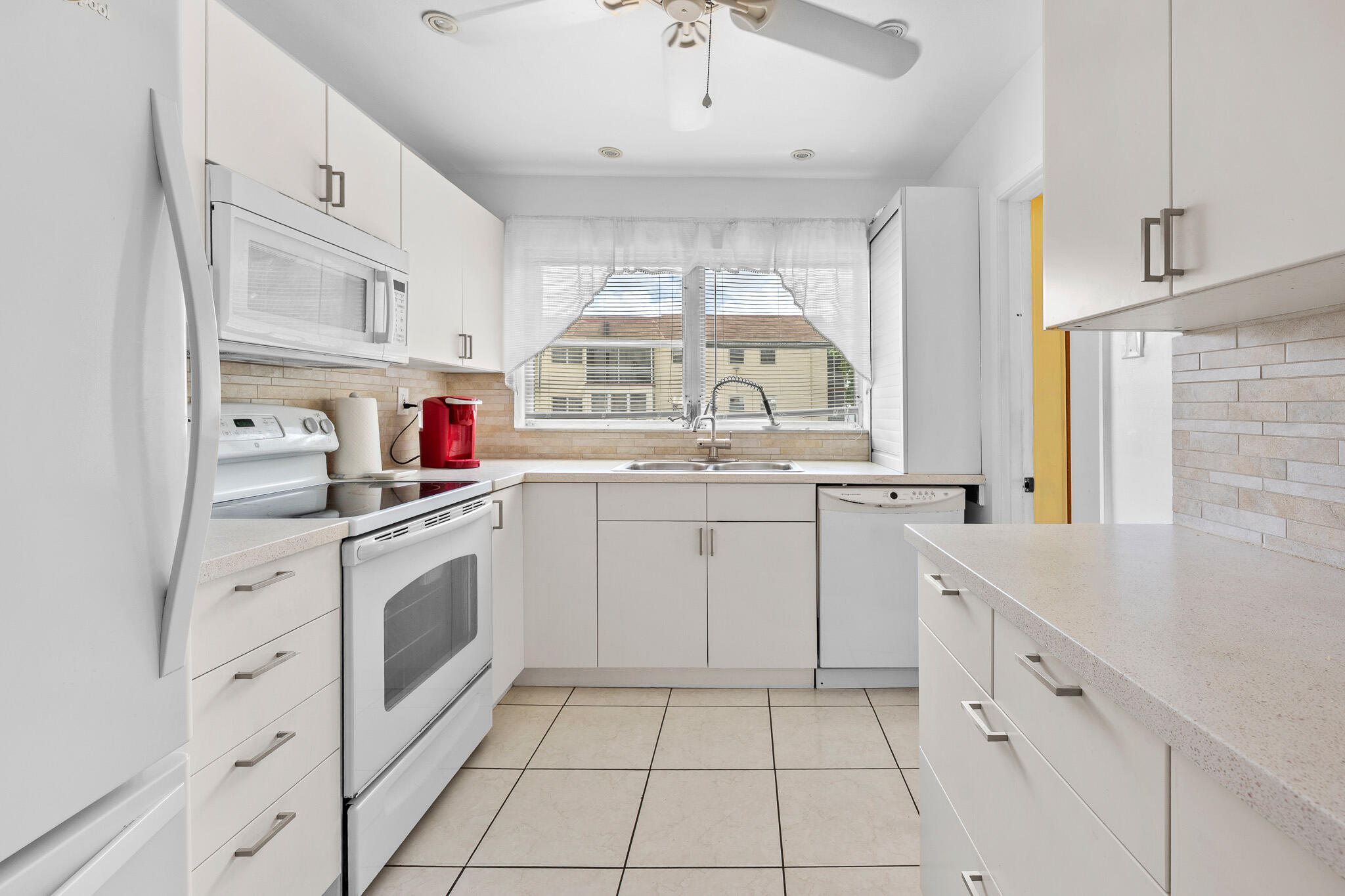 4047 Northwest 16th Street, Unit 206 Lauderhill, FL 33313 - Photo 10 of 26 a kitchen with cabinets appliances a sink and a window