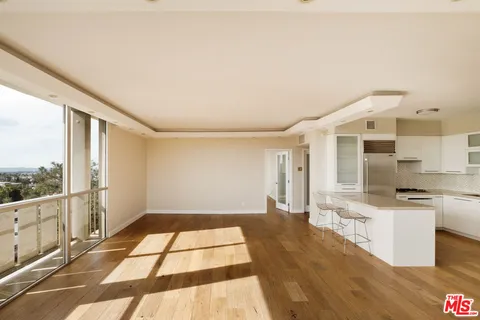 a kitchen with a sink a window and chairs