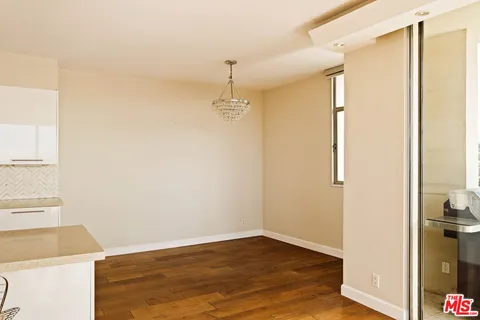 a view of a balcony with floor to ceiling window and wooden floor