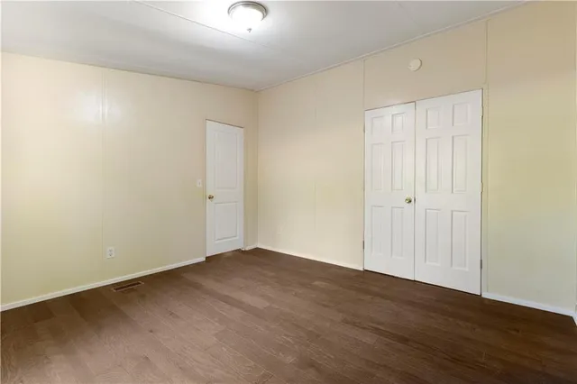 an empty room with wooden floor and a bathroom