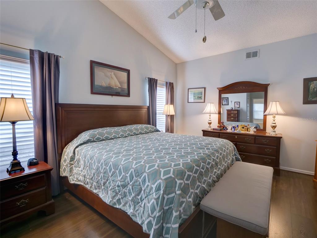 4704 River Ridge Drive Leesburg, FL 34748 - Photo 17 of 40 a bedroom with a bed and a large mirror on the dresser