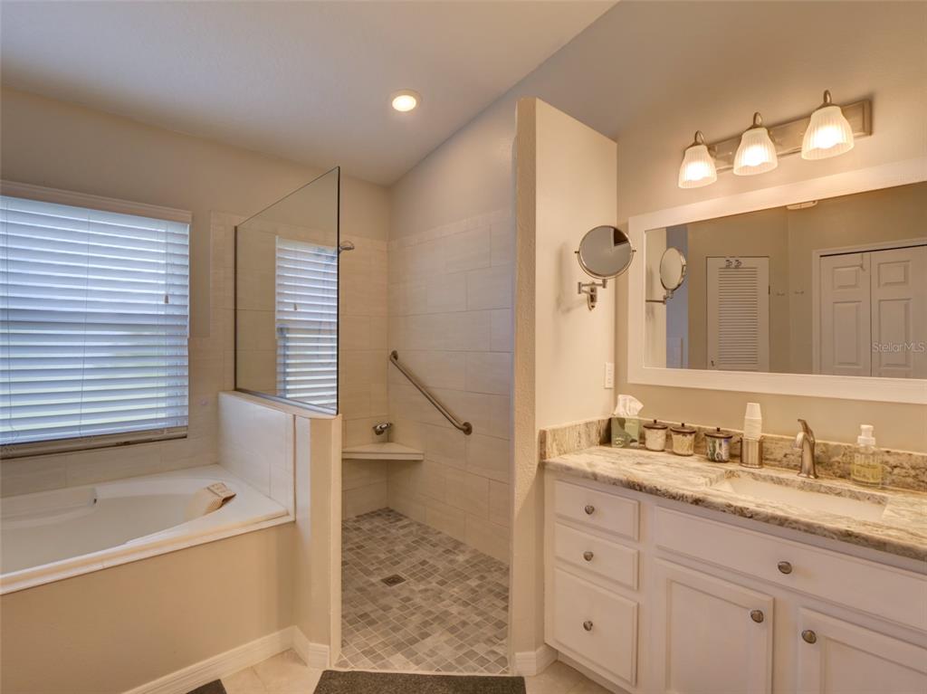 4704 River Ridge Drive Leesburg, FL 34748 - Photo 20 of 40 a bathroom with a granite countertop sink a toilet and a large mirror