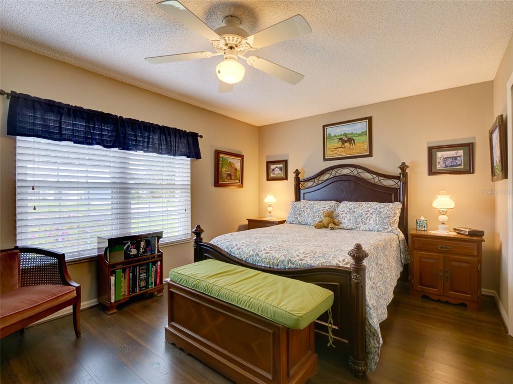 4704 River Ridge Drive Leesburg, FL 34748 - Photo 22 of 40 a bedroom with a bed and a chandelier