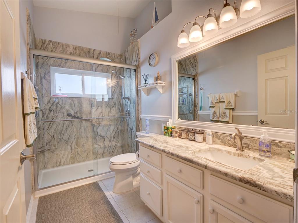 4704 River Ridge Drive Leesburg, FL 34748 - Photo 23 of 40 a bathroom with a double vanity sink mirror double toilet and shower