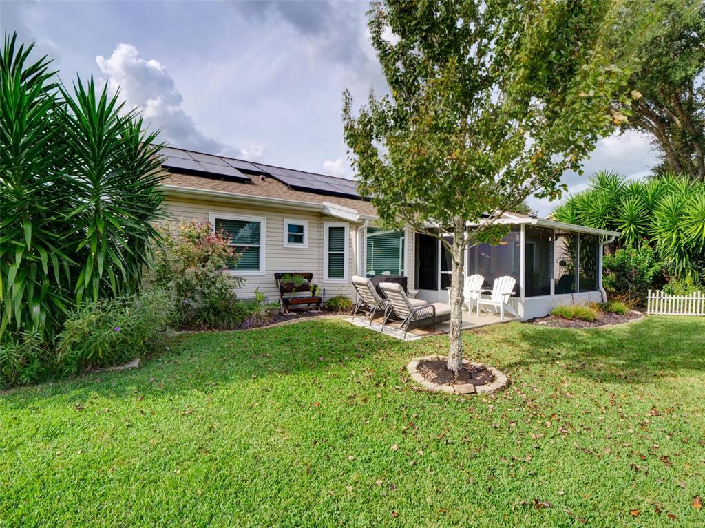 4704 River Ridge Drive Leesburg, FL 34748 - Photo 31 of 40 a view of a patio with table and chairs potted plants and large tree