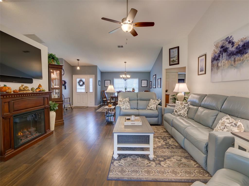 4704 River Ridge Drive Leesburg, FL 34748 - Photo 7 of 40 a living room with furniture a flat screen tv and a fireplace