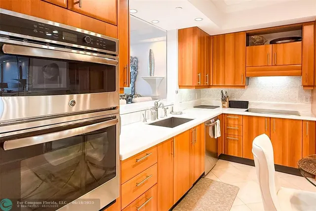a kitchen with stainless steel appliances kitchen island granite countertop a sink and cabinets