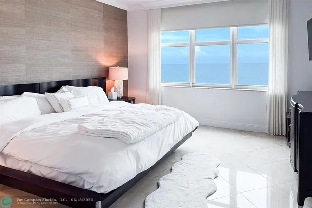 a large bed sitting in a bedroom next to a window