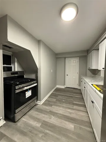 a kitchen with stove cabinets and stainless steel appliances
