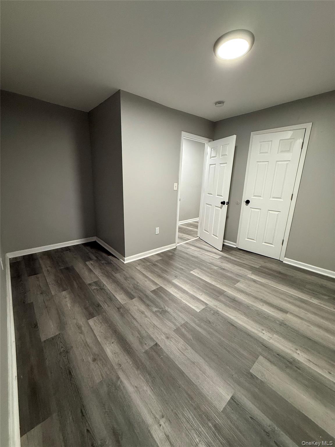 7 Grant Street, Unit 1 Poughkeepsie, NY 12601 - Photo 7 of 9 an empty room with wooden floor and windows
