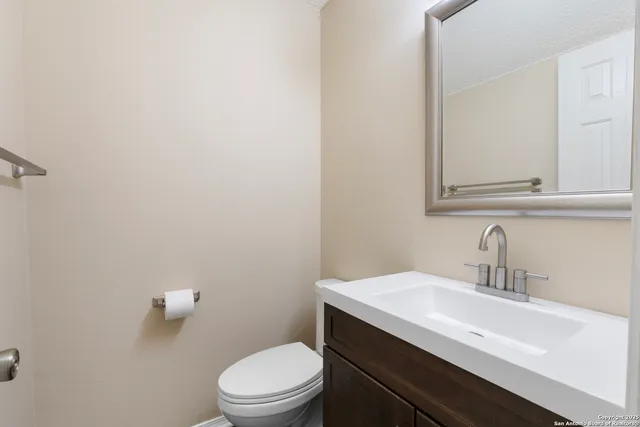 a bathroom with a sink a toilet and mirror