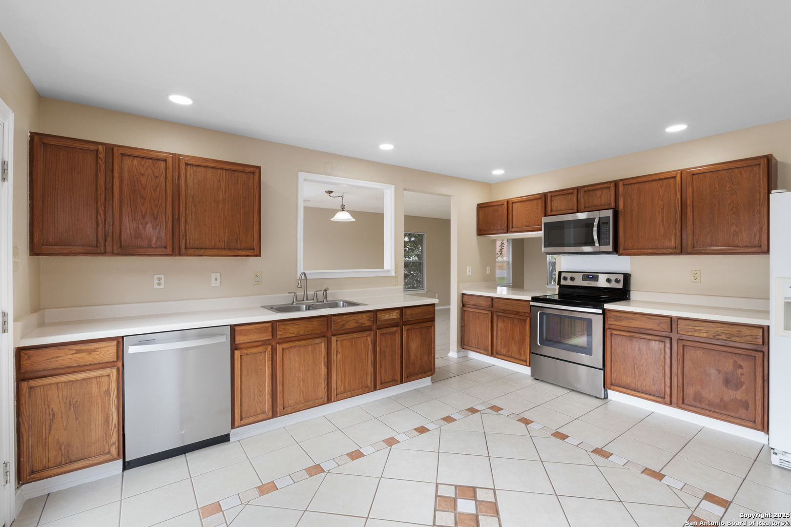 1555 Jasmine Schertz, TX 78154 - Photo 9 of 23 a kitchen with stainless steel appliances granite countertop a stove top oven a sink dishwasher and a refrigerator with wooden cabinets