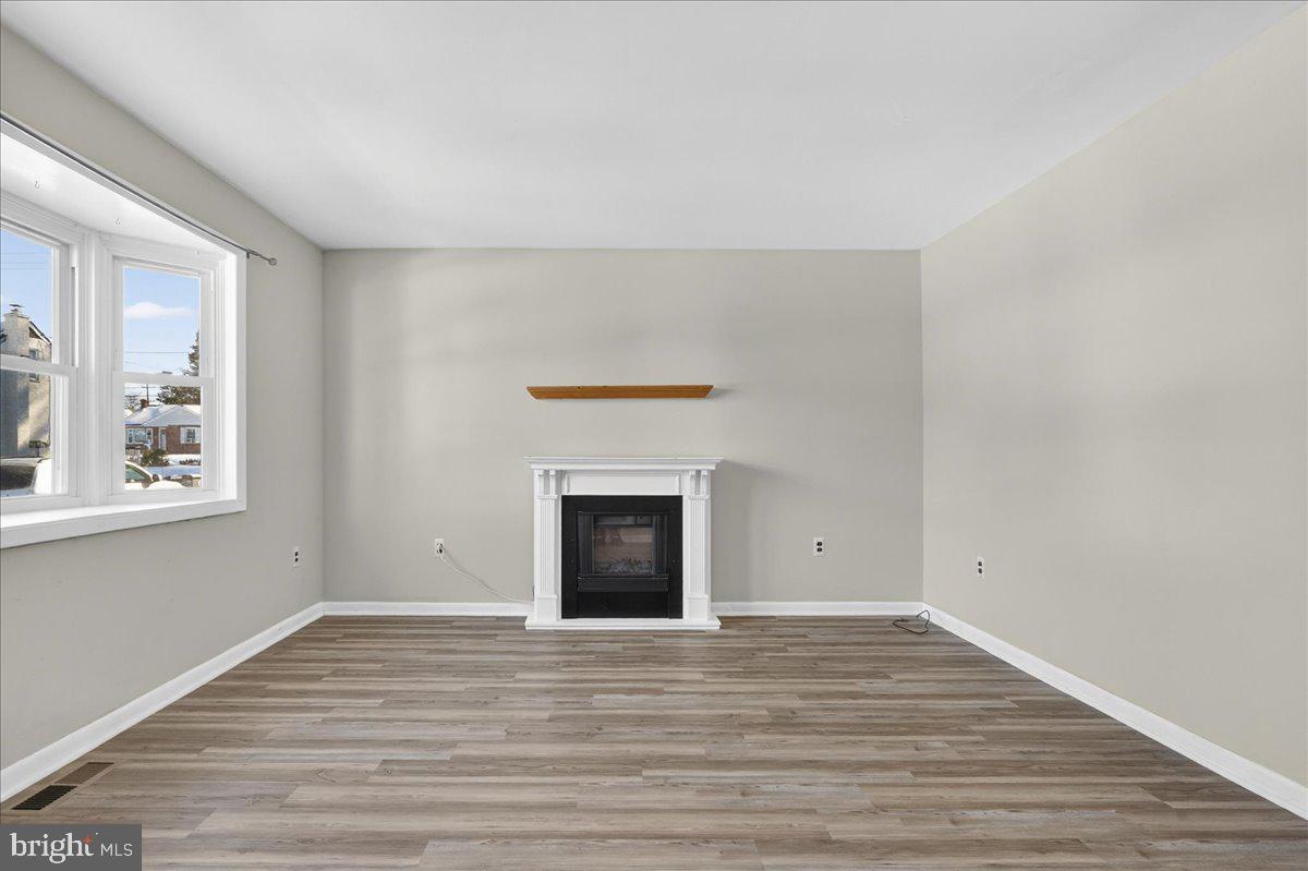 1158 Grove Street Pottstown, PA 19464 - Photo 5 of 26 a view of empty room with wooden floor and fireplace