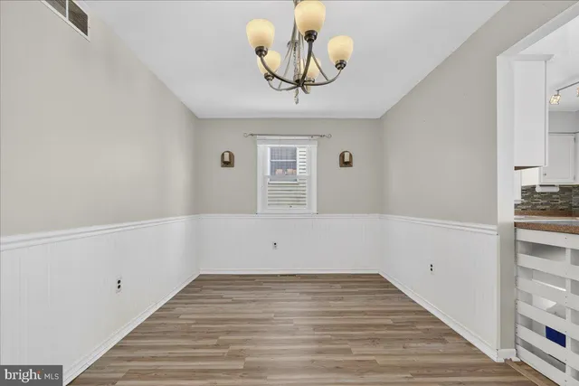 a kitchen with stainless steel appliances granite countertop a refrigerator a stove a sink dishwasher and white cabinets with wooden floor