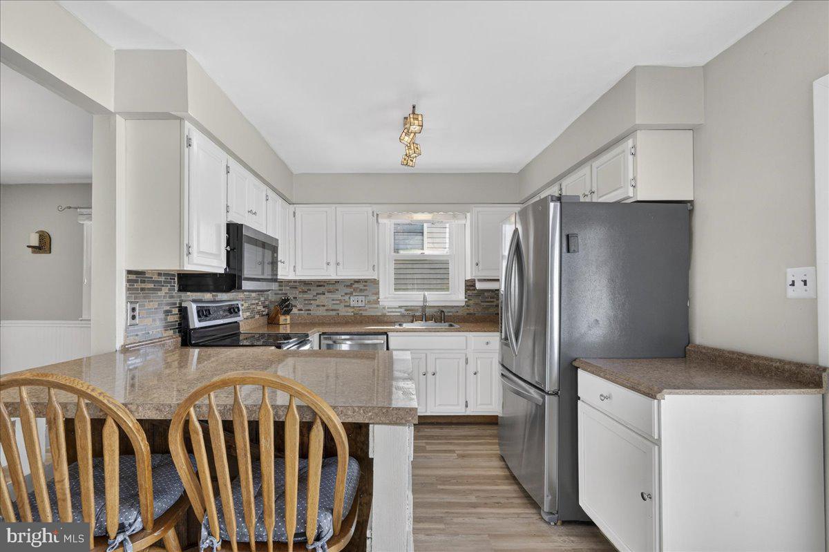 1158 Grove Street Pottstown, PA 19464 - Photo 10 of 26 a kitchen with stainless steel appliances granite countertop a refrigerator a stove a sink dishwasher and white cabinets with wooden floor