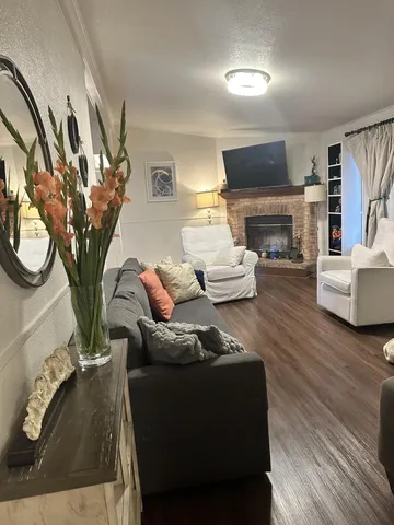 a living room with furniture a fireplace and a flat screen tv