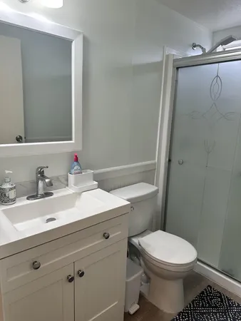 a bathroom with a sink a toilet and shower