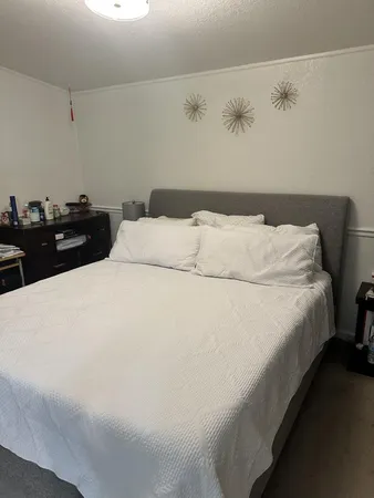a bed sitting in a bedroom and dresser