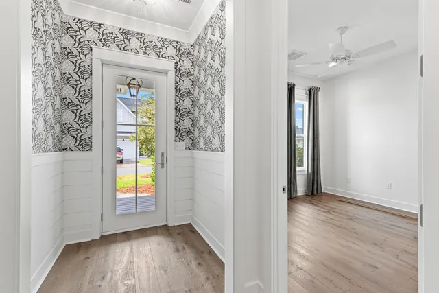 a view of a hallway with wooden floor and staircase
