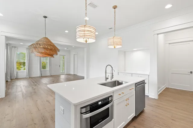 a kitchen that has a lot of cabinets and wooden floor
