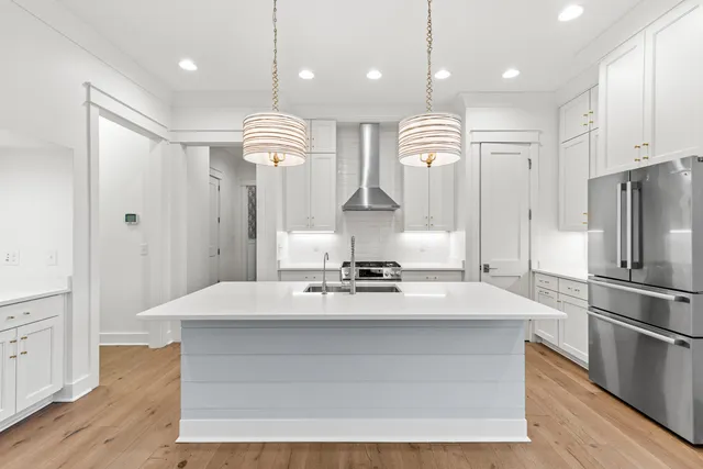 a kitchen with kitchen island white cabinets and stainless steel appliances