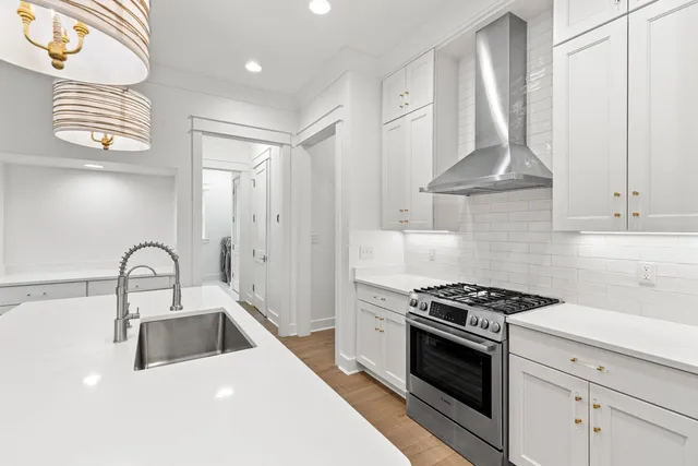 a kitchen with granite countertop a sink stainless steel appliances and cabinets