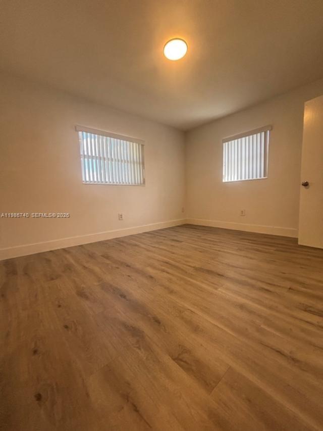 5215 Southwest 128th Avenue Miami, FL 33175 - Photo 7 of 20 an empty room with wooden floor and windows