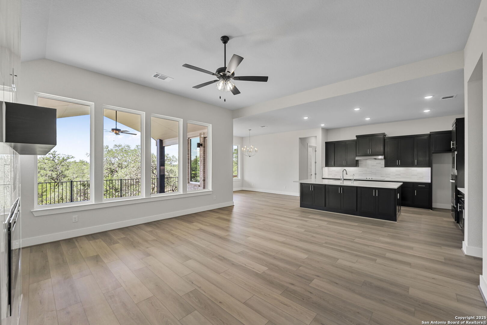 6821 Arbor Falls Fair Oaks Ranch, TX 78015 - Photo 11 of 50 a large kitchen with kitchen island a island wooden floor and a large window