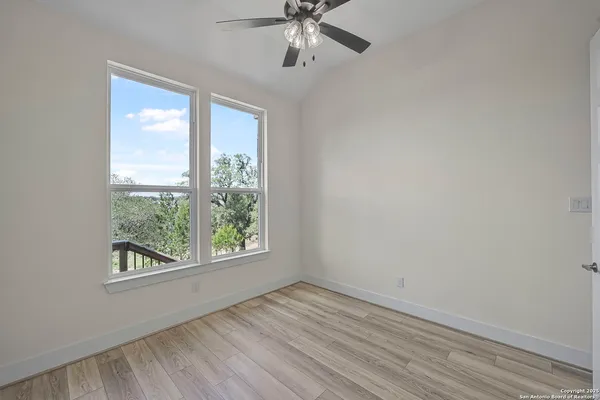 an empty room with a window and ceiling fan