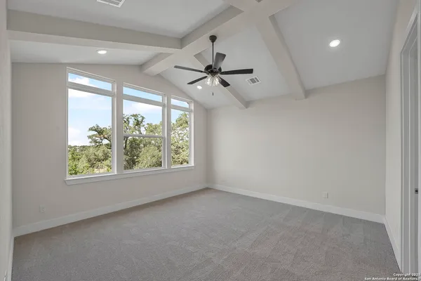 en empty room with windows and ceiling fan
