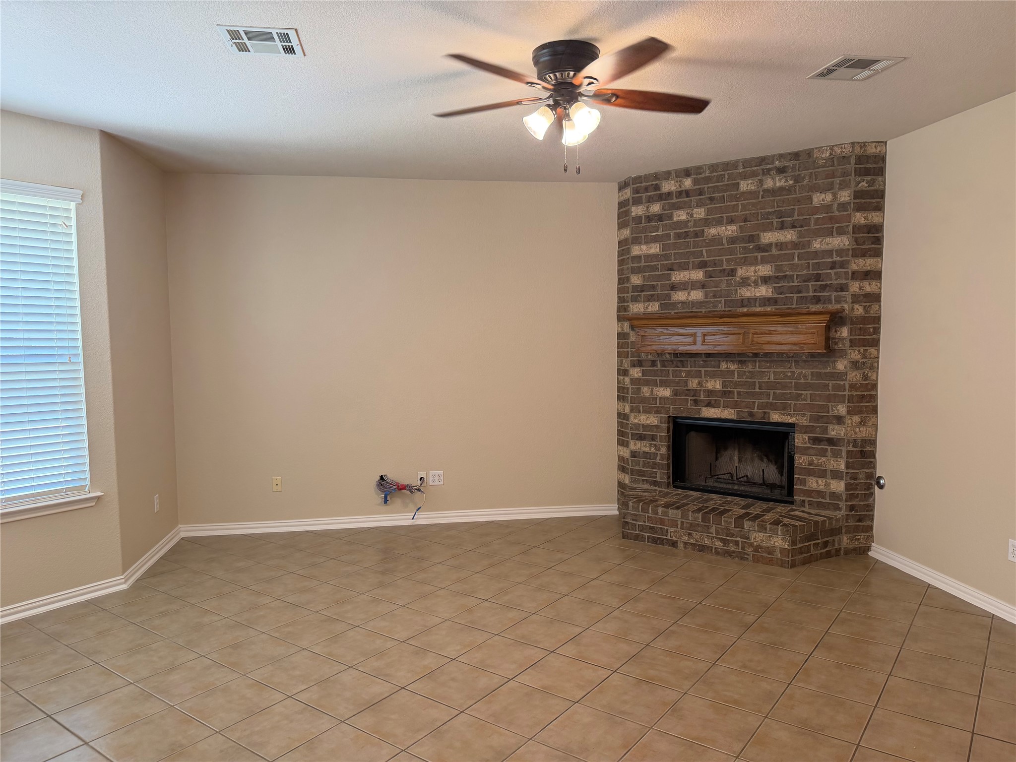 3021 Grand Mission Way Pflugerville, TX 78660 - Photo 9 of 31 A corner fireplace with a brick surround provides a cozy anchor to this inviting living space.
