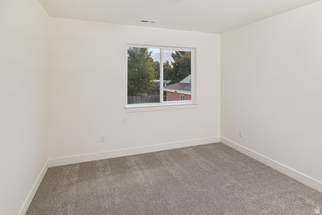612 North 400 West Logan, UT 84321 - Photo 24 of 27 Neutral-toned room featuring a window with white trim, light-colored walls, and gray carpet