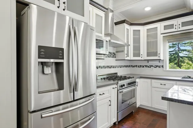 a kitchen with stainless steel appliances white cabinets and a refrigerator