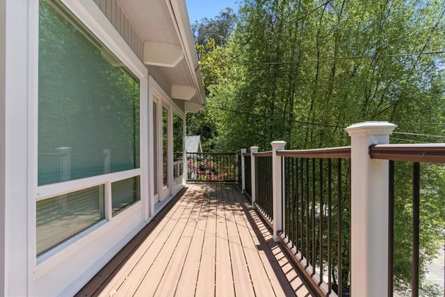 a view of balcony with wooden floor and fence