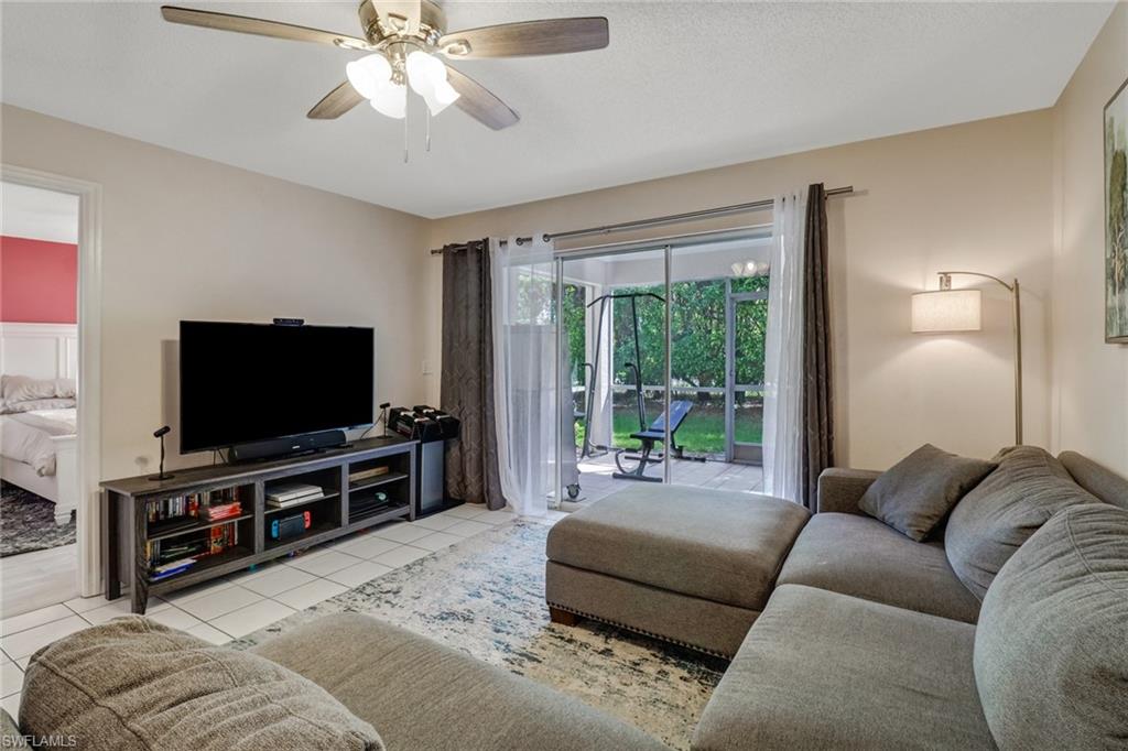 7750 Jewel Lane, Unit 101 Naples, FL 34109 - Photo 12 of 28 a living room with furniture and a flat screen tv