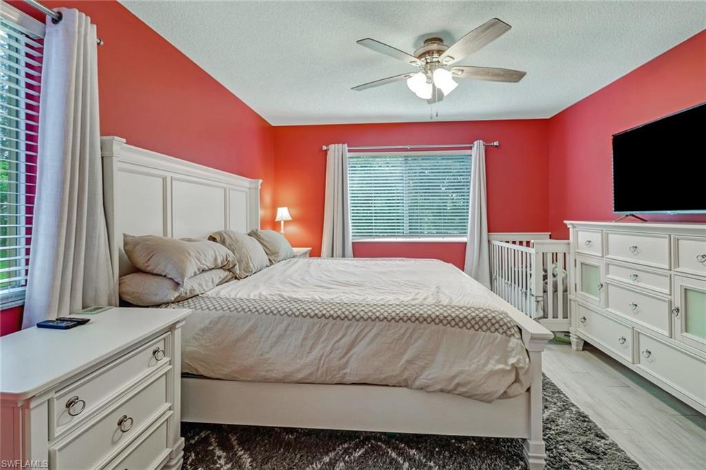 7750 Jewel Lane, Unit 101 Naples, FL 34109 - Photo 14 of 28 a bedroom with a large bed and a flat screen tv