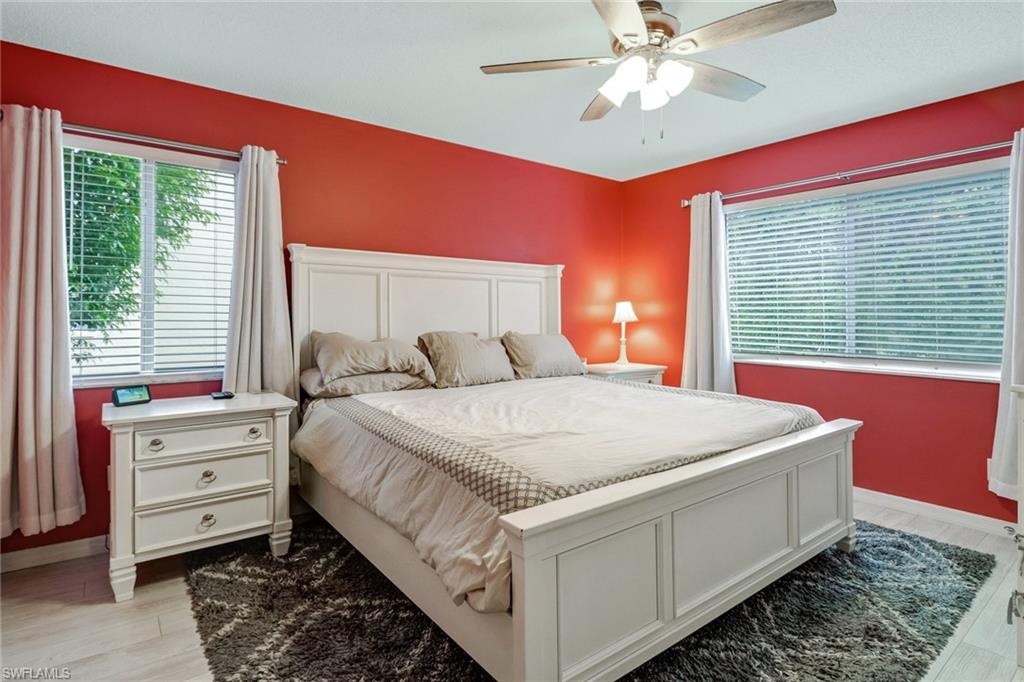 7750 Jewel Lane, Unit 101 Naples, FL 34109 - Photo 15 of 28 a bed room with a bed and a chandelier