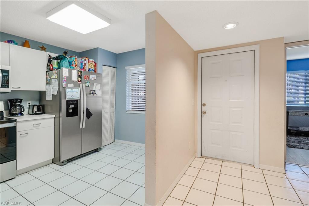 7750 Jewel Lane, Unit 101 Naples, FL 34109 - Photo 2 of 28 a kitchen with stainless steel appliances a refrigerator and cabinets
